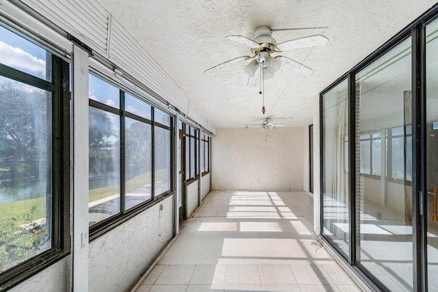 unfurnished sunroom featuring ceiling fan