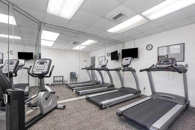 workout area featuring carpet and a drop ceiling