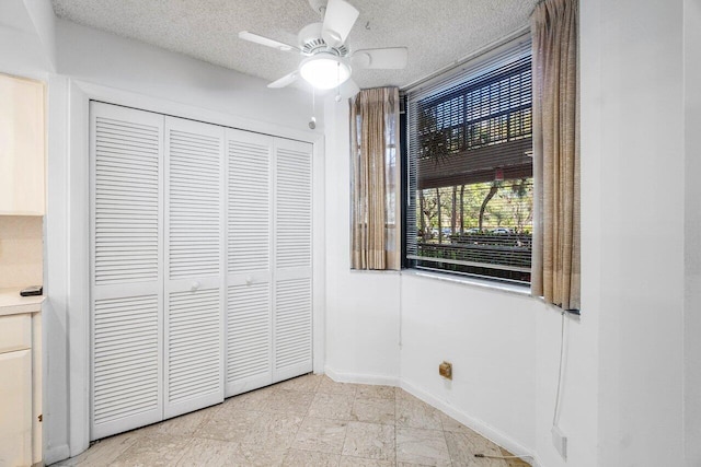 unfurnished bedroom featuring ceiling fan, a closet, and a textured ceiling