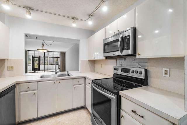 kitchen with white cabinets, sink, hanging light fixtures, a textured ceiling, and stainless steel appliances