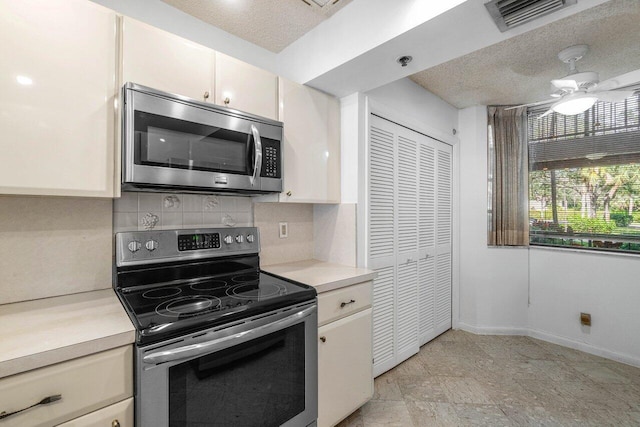 kitchen with backsplash, white cabinets, ceiling fan, a textured ceiling, and appliances with stainless steel finishes