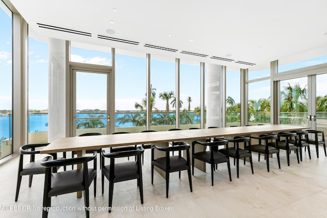 sunroom featuring a water view