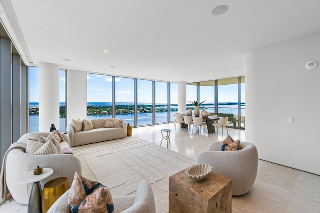 living room with a water view, a healthy amount of sunlight, and floor to ceiling windows