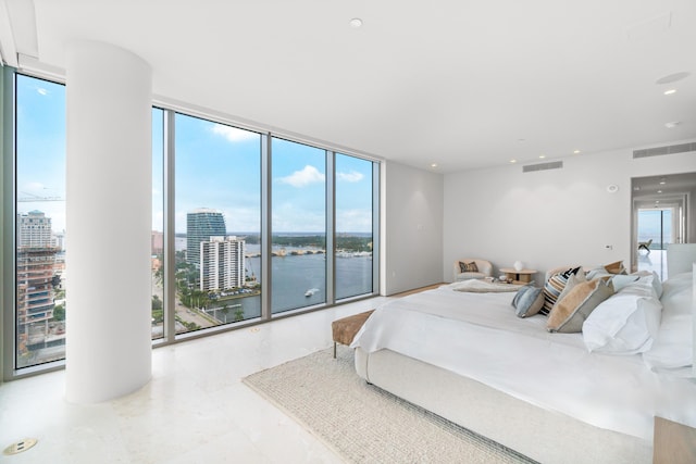 bedroom featuring a water view, floor to ceiling windows, and access to outside