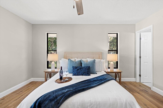 bedroom with wood-type flooring, a textured ceiling, and ceiling fan