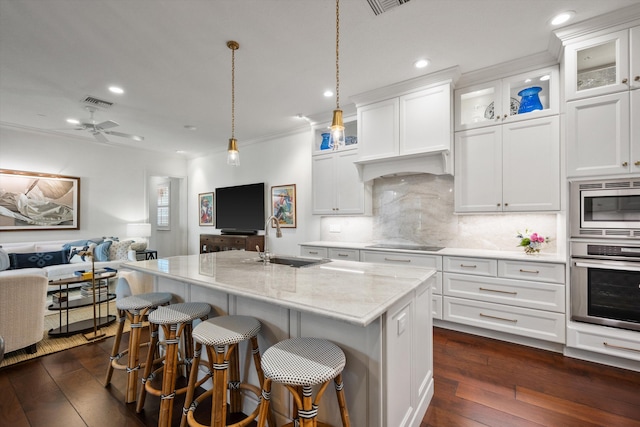 kitchen featuring white cabinets, appliances with stainless steel finishes, sink, and a center island with sink