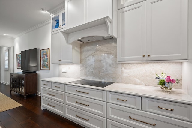 kitchen with white cabinets, decorative backsplash, black electric cooktop, and ornamental molding