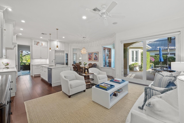 living room featuring ceiling fan, dark hardwood / wood-style floors, and sink