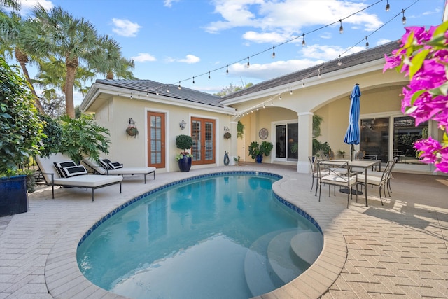 view of pool featuring a patio area and french doors