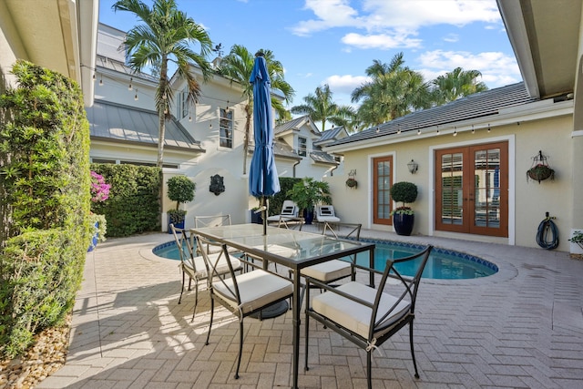 view of swimming pool with french doors and a patio