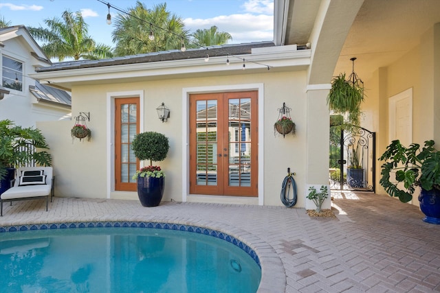 view of pool with french doors and a patio area