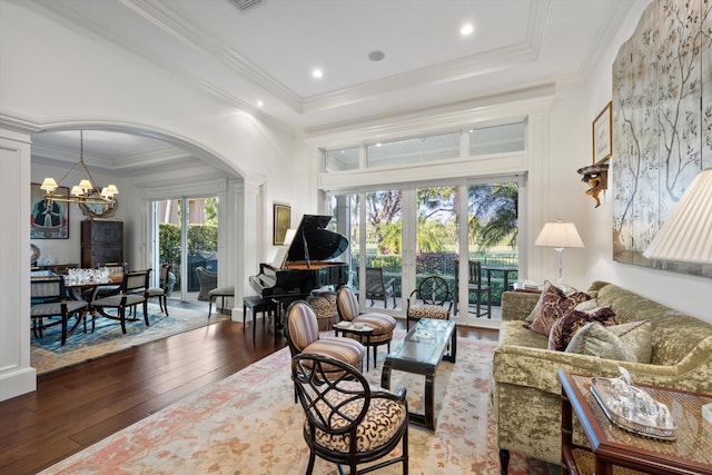 living room with an inviting chandelier, ornamental molding, and hardwood / wood-style flooring