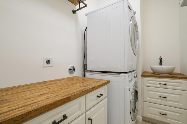 laundry room with cabinets and stacked washer and dryer