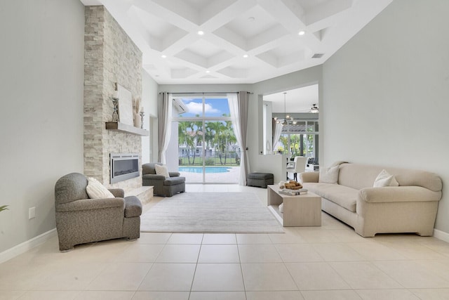 tiled living room with a stone fireplace, a towering ceiling, coffered ceiling, ceiling fan, and beam ceiling