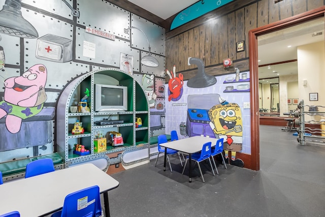 recreation room featuring wooden walls