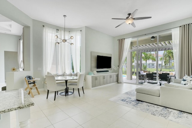 living room featuring light tile patterned floors and ceiling fan with notable chandelier