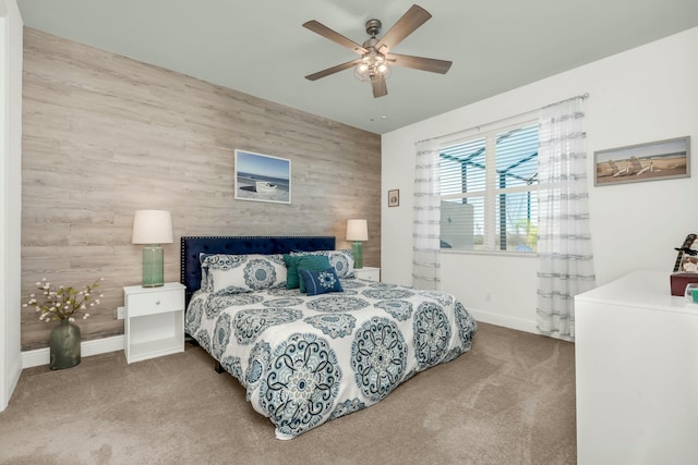 carpeted bedroom with ceiling fan and wooden walls