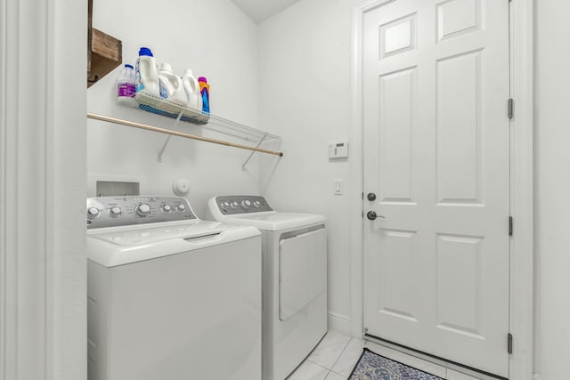 clothes washing area with washing machine and dryer and light tile patterned floors