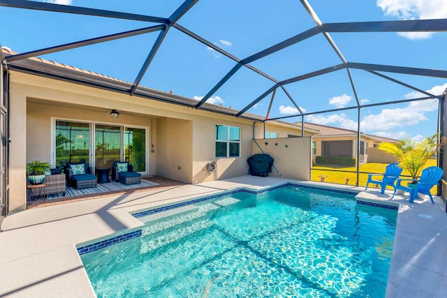 view of pool with outdoor lounge area, ceiling fan, a lanai, and a patio area