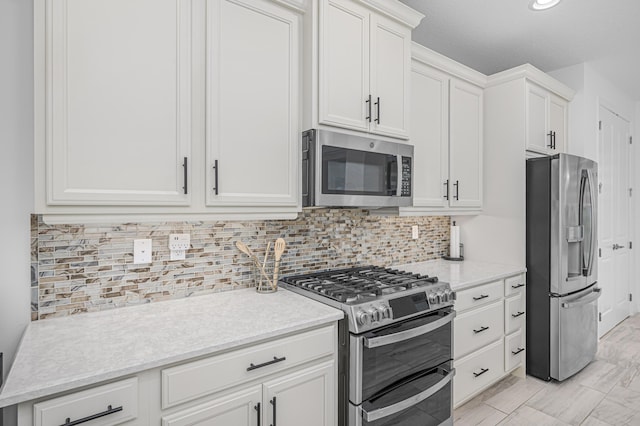 kitchen featuring tasteful backsplash, appliances with stainless steel finishes, light stone counters, and white cabinets