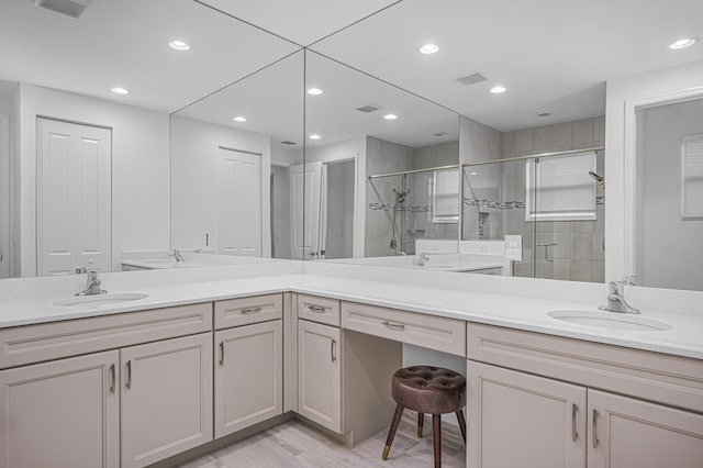 bathroom with vanity, hardwood / wood-style flooring, and a shower with shower door