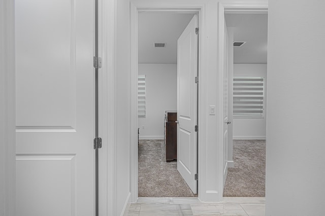 hallway with light colored carpet