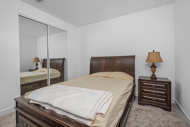 bedroom with light colored carpet and a closet