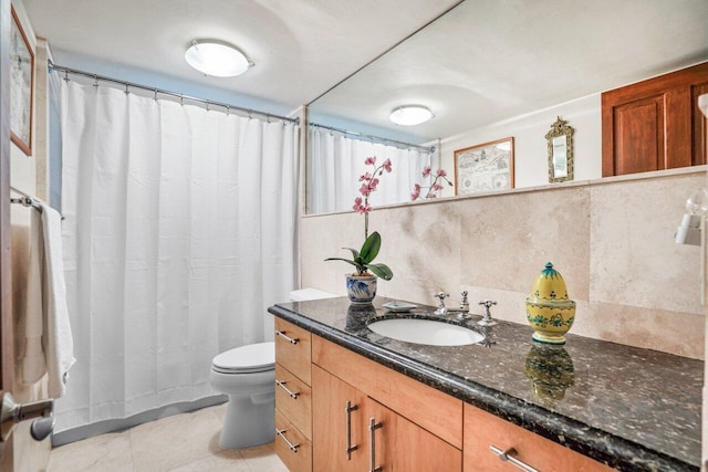 bathroom with tasteful backsplash, vanity, and toilet