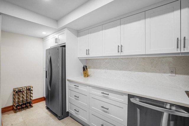 kitchen with stainless steel appliances, light tile patterned floors, tasteful backsplash, and white cabinetry