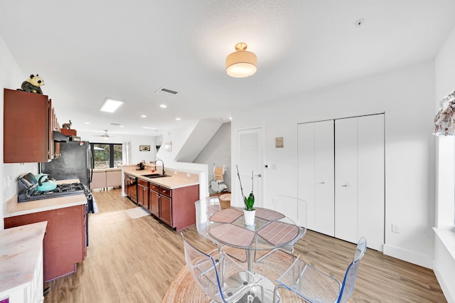 kitchen with ceiling fan, sink, black appliances, and light hardwood / wood-style flooring