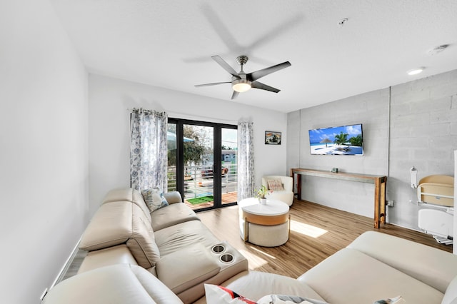 living room with light wood-type flooring, french doors, a textured ceiling, and ceiling fan