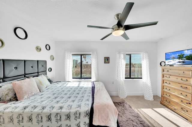 bedroom featuring light carpet, ceiling fan, and multiple windows