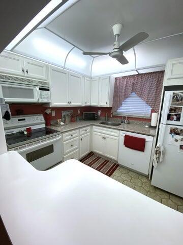 kitchen with white cabinetry, sink, ceiling fan, and white appliances