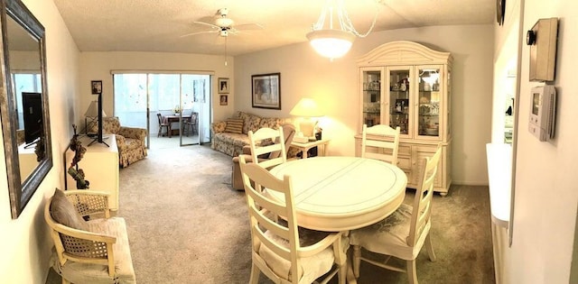 carpeted dining room featuring a textured ceiling, ceiling fan, and lofted ceiling