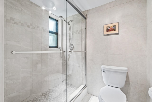 bathroom featuring toilet and a shower with shower door