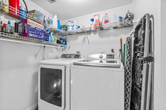 washroom with washer and clothes dryer and a textured ceiling