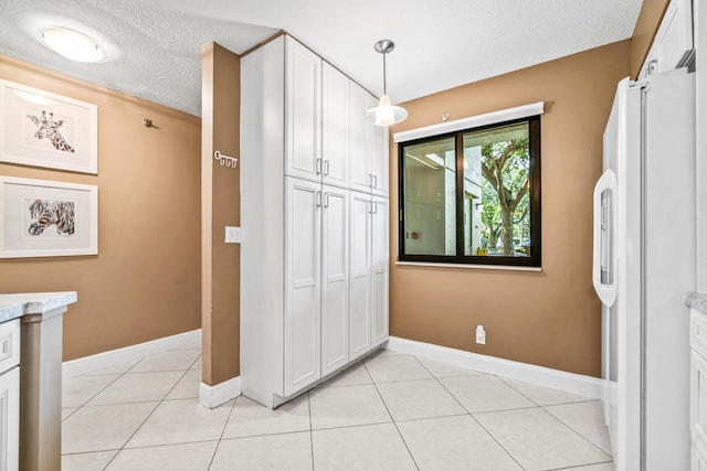 tiled bedroom with white fridge, a textured ceiling, and a closet