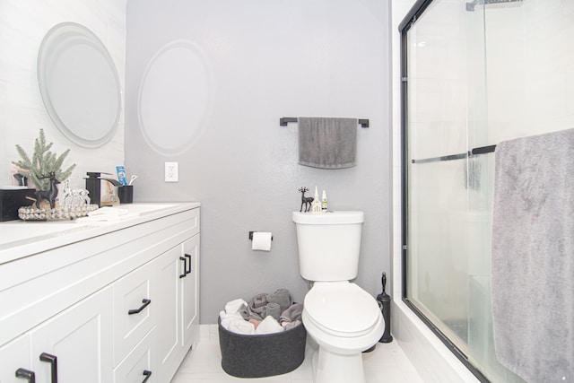 bathroom featuring tile patterned floors, vanity, an enclosed shower, and toilet