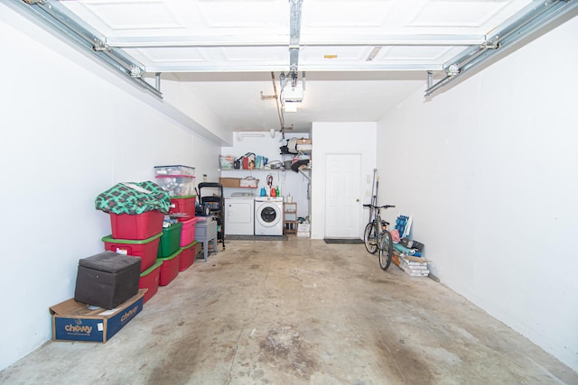 garage with separate washer and dryer and a garage door opener