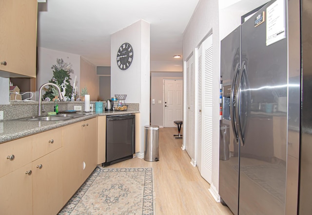 kitchen with black dishwasher, sink, light hardwood / wood-style floors, and stainless steel refrigerator with ice dispenser