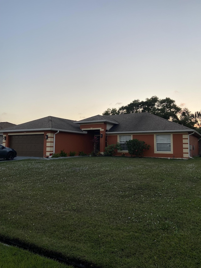 view of front facade with a garage and a yard