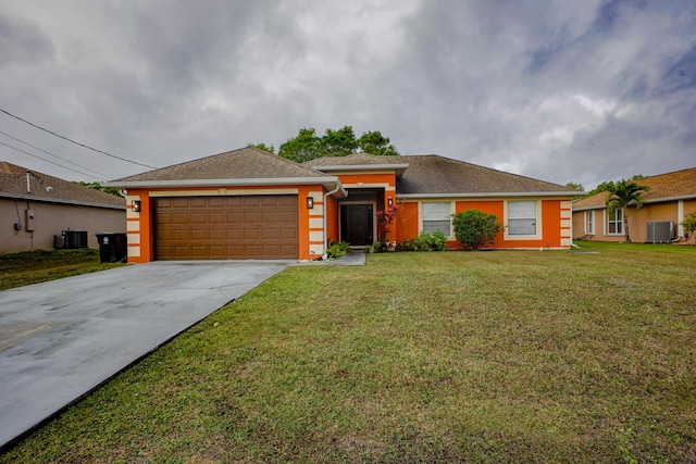 view of front of property featuring a garage, central AC, and a front yard