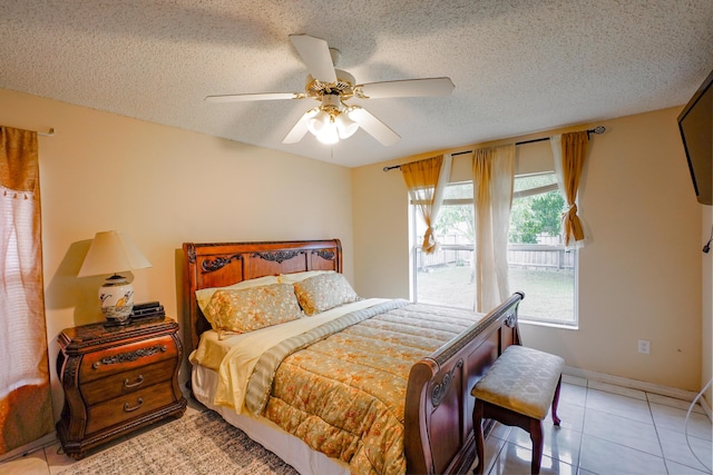 bedroom featuring ceiling fan, a textured ceiling, and light tile patterned floors