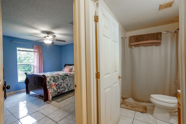 bedroom featuring a textured ceiling, ceiling fan, and light tile patterned flooring