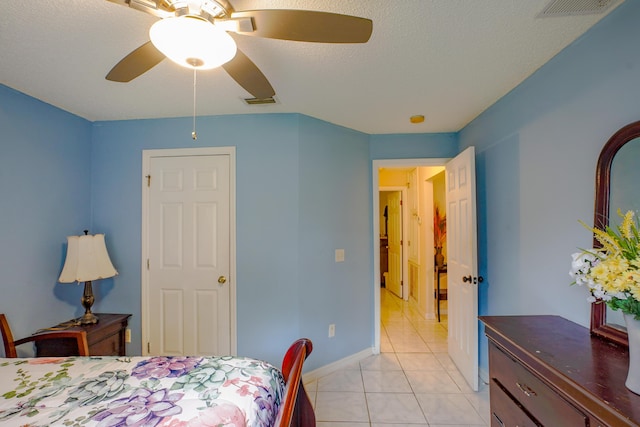 tiled bedroom featuring ceiling fan and a textured ceiling