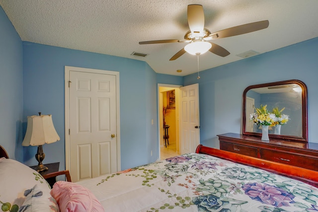 tiled bedroom featuring ceiling fan and a textured ceiling