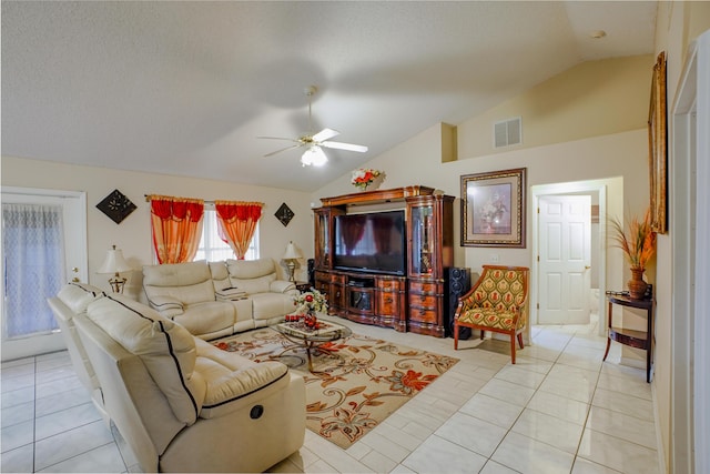 tiled living room with a textured ceiling, vaulted ceiling, and ceiling fan