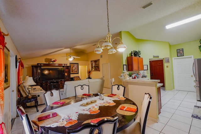 dining area with ceiling fan with notable chandelier, vaulted ceiling, and light tile patterned floors