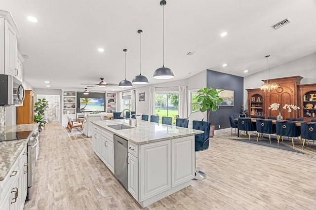 kitchen with white cabinetry, sink, ceiling fan with notable chandelier, and appliances with stainless steel finishes