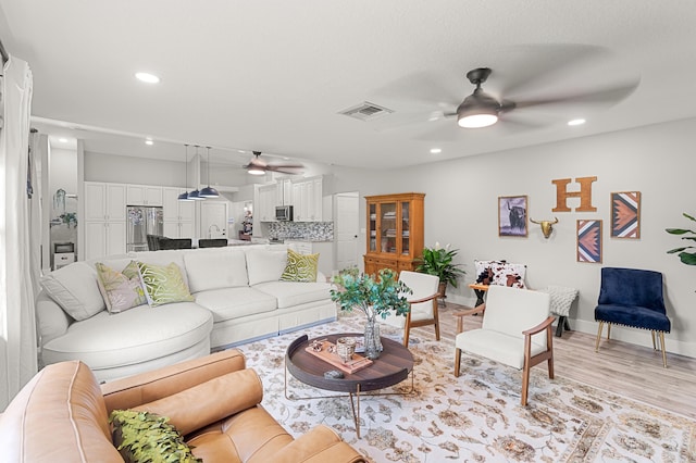 living room featuring light hardwood / wood-style floors and ceiling fan